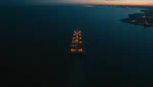 Pétrolier traversant un détroit stratégique au crépuscule, sur fond de volatilité des marchés de l’énergie